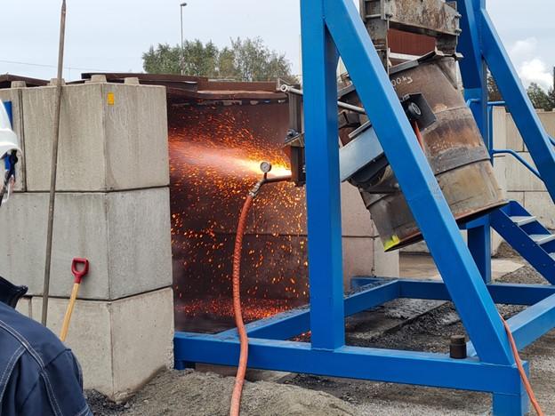 Granulering pågår. Slaggen slungas med hjälp av vattenstrålar in i ett betongfack för senare uppsamling.